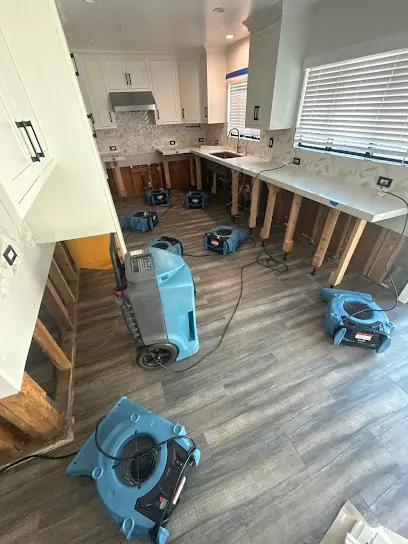 Air movers drying a room with the baseboards removed