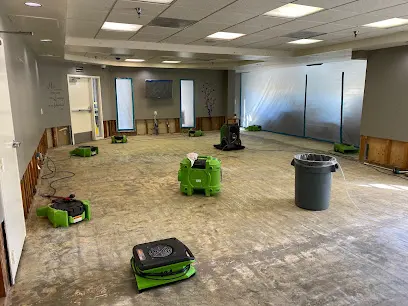 Air movers drying a commercial room after water damage