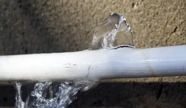 A burst water supply pipe spraying water in a Pomona, CA home